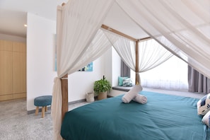 A bedroom with a canopy bed, a potted plant, a bench, and a view of the outdoors.