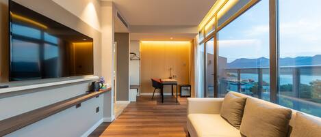 Una sala de estar moderna con un sofá, un televisor montado en la pared y una zona de comedor con mesa y sillas.