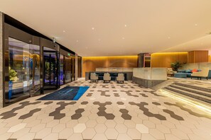 A modern lobby with a hexagonal patterned floor, a reception desk, and seating area. - Holiday Inn Express Yichang Riverside by IHG (Yichang)
