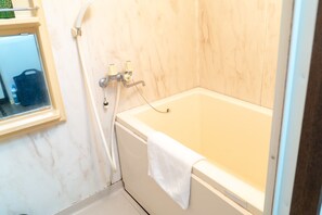 Appartement | Badkamer | Een aparte badkuip en douche, een diep bad, een haardroger