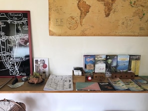 A desk with a Fujiyoshida map, a world map, and various travel brochures. - Fuji Matsuyama Base (Fujiyoshida)