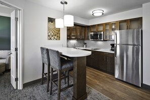 A modern kitchen with a central island, stainless steel appliances, and wooden cabinets. - Staybridge Suites Irvine-John Wayne Airport by IHG (Irvine)