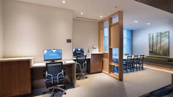 A modern office space with two desks, chairs, and a large window.