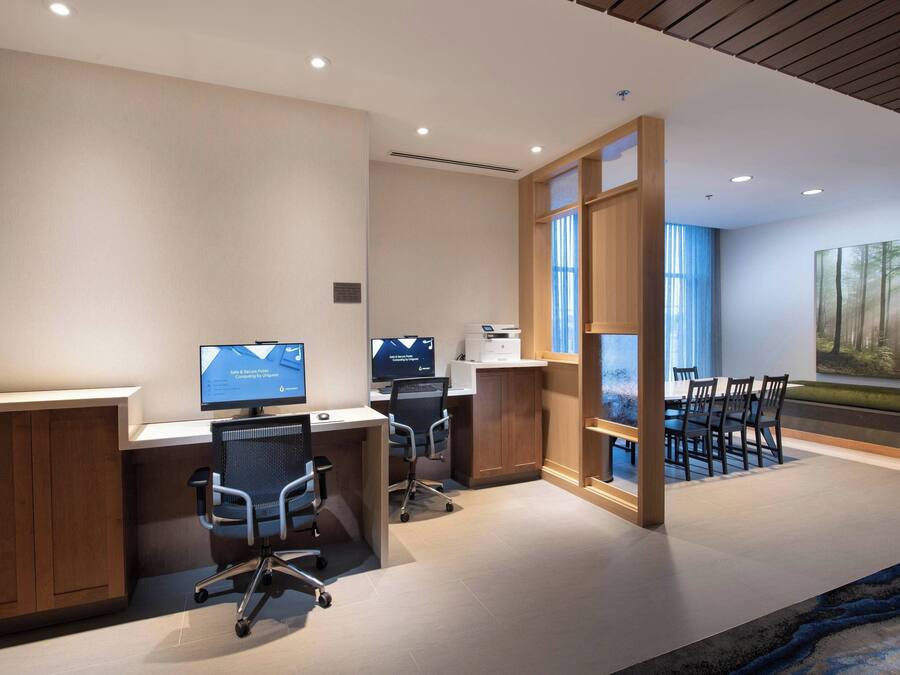 A modern office space with two desks, chairs, and a large window.