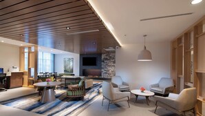 A modern living room with a fireplace, comfortable seating, and a large TV.