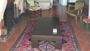 Una sala de estar con chimenea, un sofá, una mesa de centro y dos sillones.