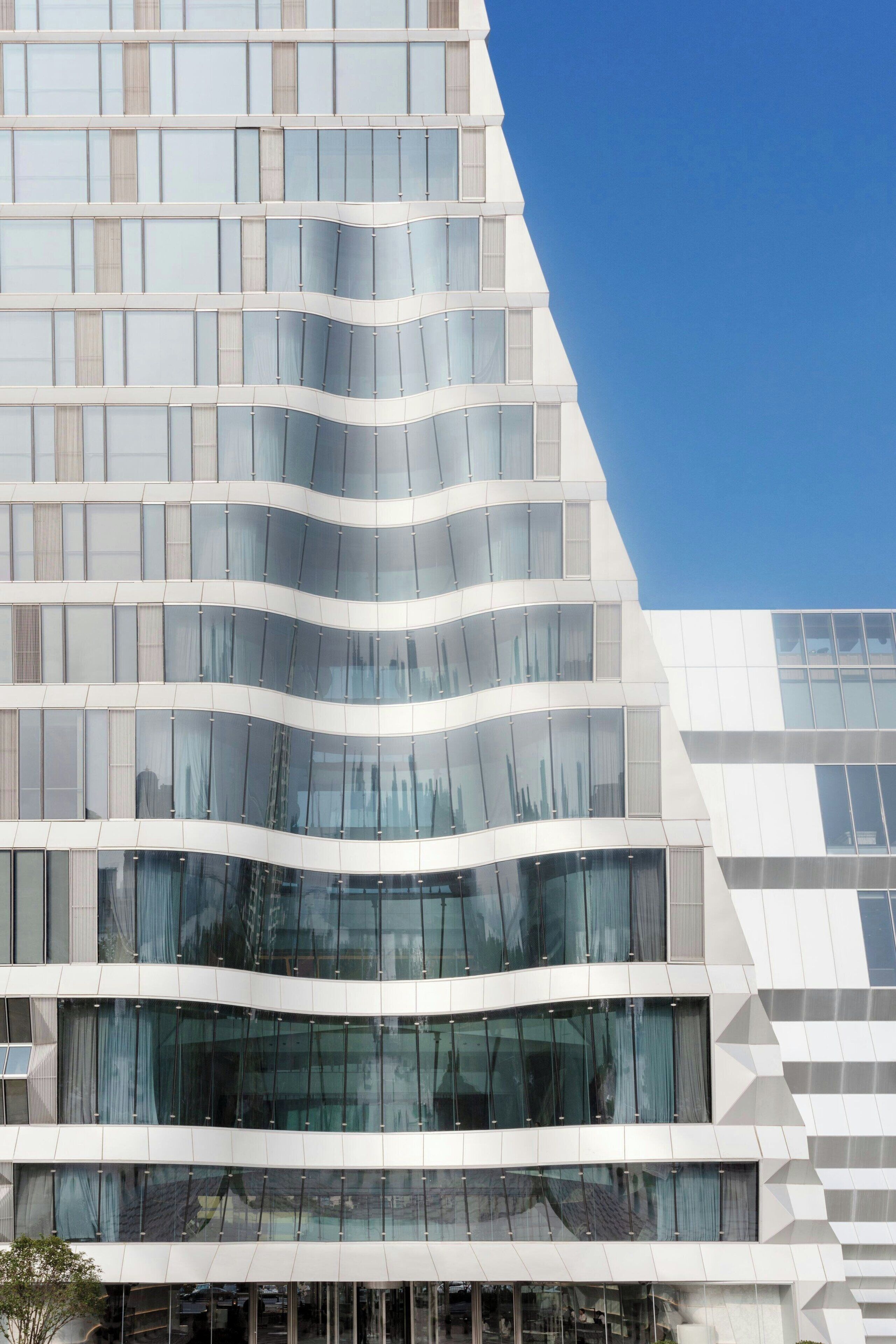 Un edificio moderno con fachada curva y grandes ventanales.