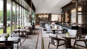 Un vaste espace intérieur doté de grandes fenêtres, d’un coin salon aménagé et d’une cuisine moderne en arrière-plan.