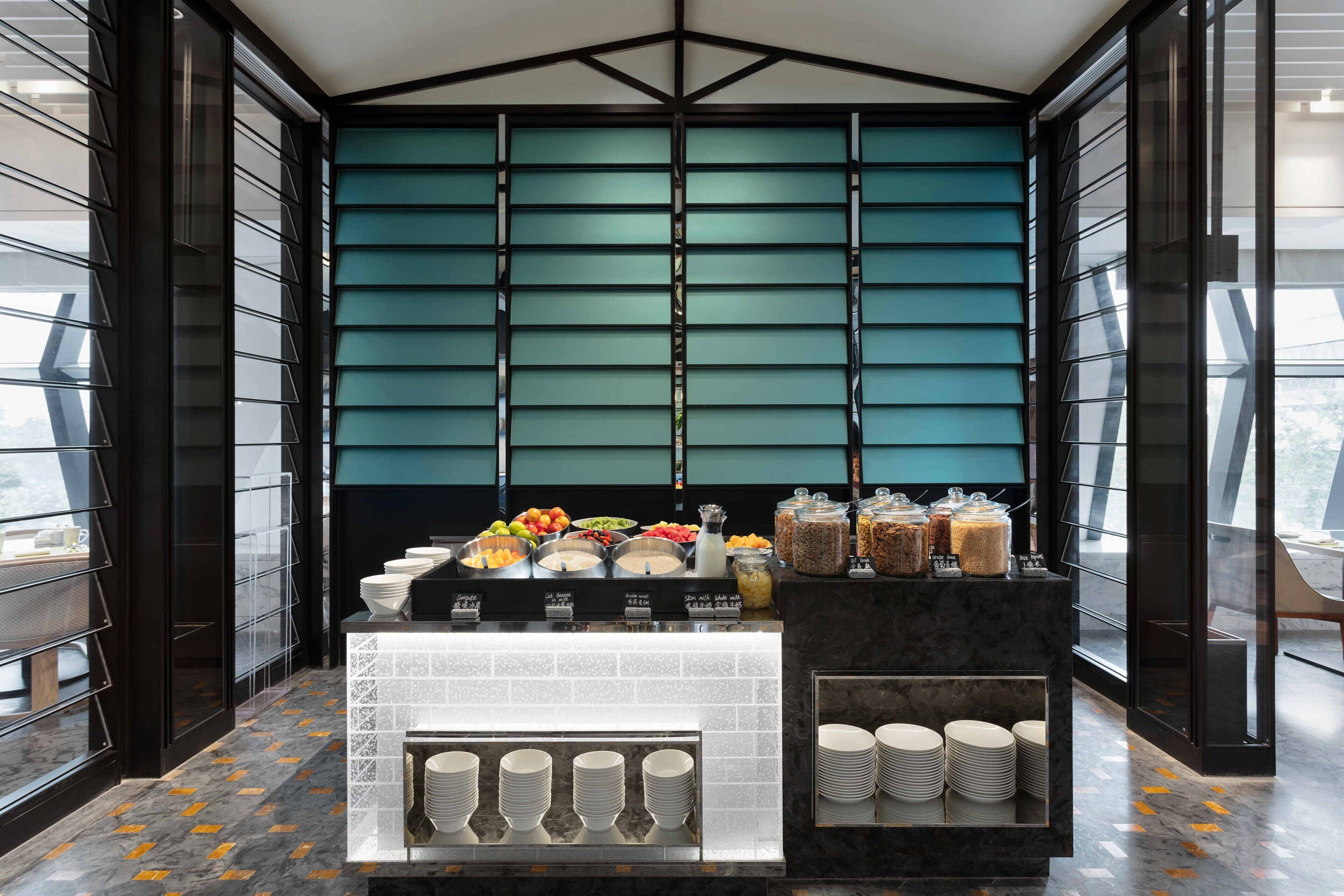 A breakfast buffet area with a variety of food options and a modern design.