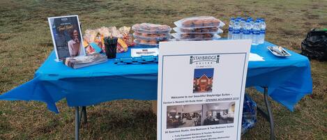 A promotional table for Staybridge Suites with amenities like fully equipped kitchens, complimentary breakfast, and a fitness center.