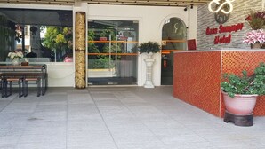 A hotel reception area with a reception desk, seating area, and potted plants. - Cess Summer Boutique Hotel (Kalibo)