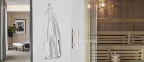 Un moderno spa con mamparas de vidrio, bancos de madera y una sauna.