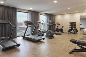 Une salle de sport équipée de tapis de course, de vélos elliptiques et de matériel de musculation.
