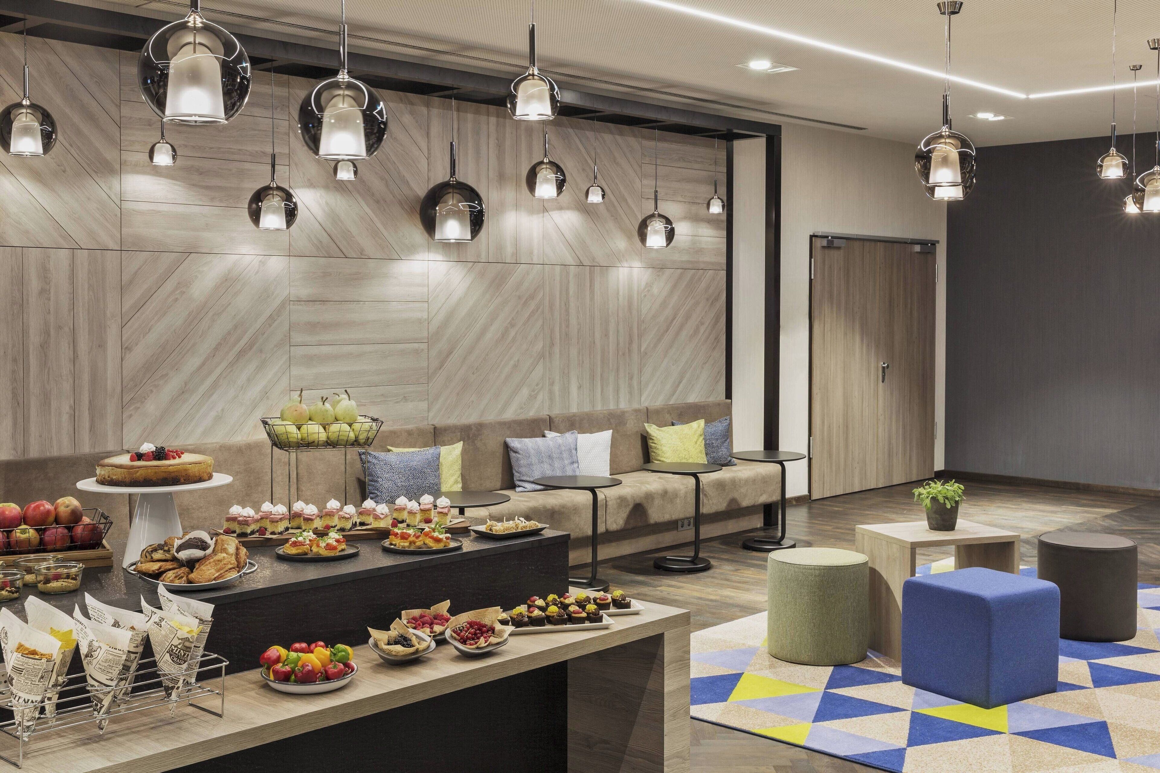 A modern lounge area with a buffet, seating, and decorative lighting.