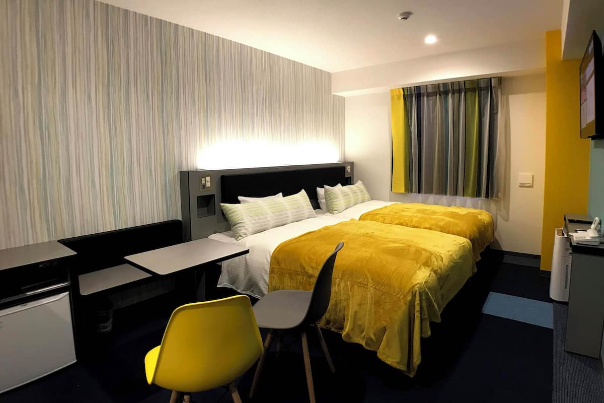 Une chambre d’hôtel équipée d’un lit, d’un bureau, d’une chaise et d’une petite kitchenette.