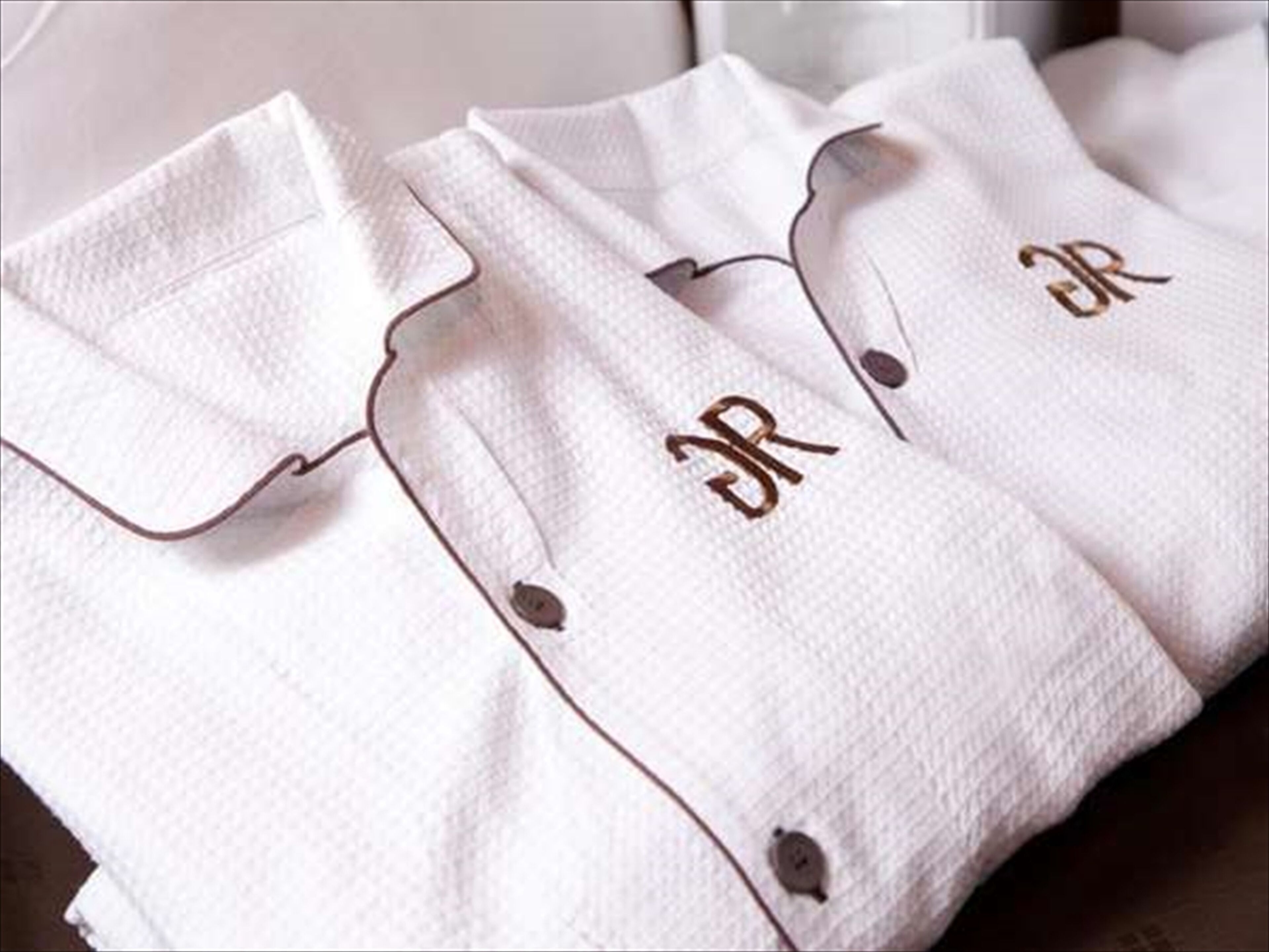 Una camisa blanca con un botón y un monograma en el puño.
