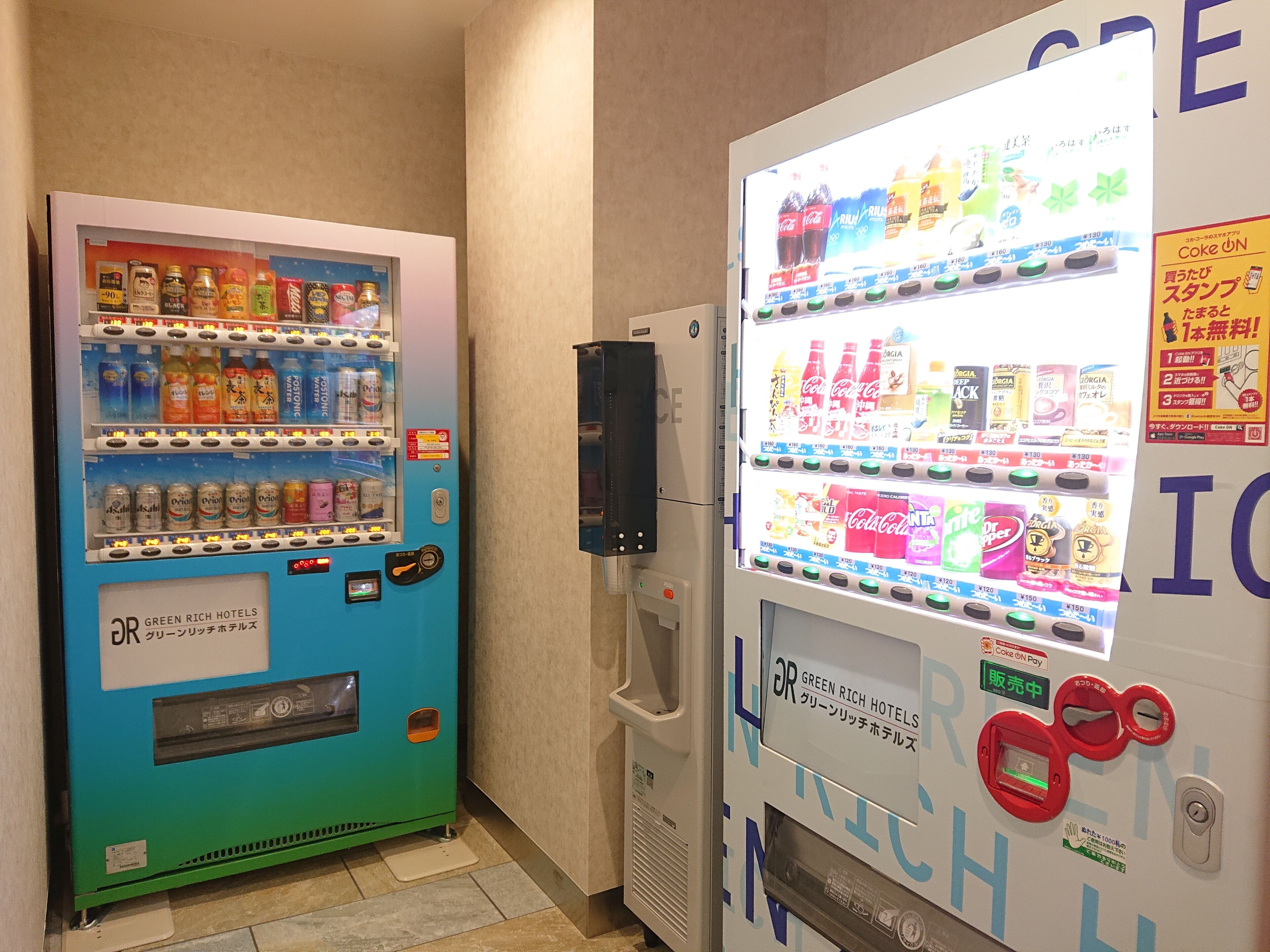 Two vending machines with drink options and a Coca-Cola machine, both labeled "Green Rich Hotels".