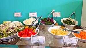 Een buffet met verschillende salades en groenten, elk met hun naam in het Japans aangeduid.