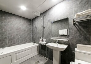 A modern bathroom with a bathtub, sink, and shower. - Shilla E Stay Motel (Yeosu)