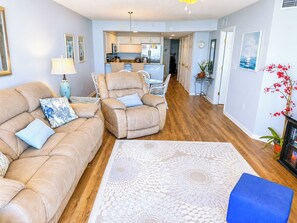 A living room with a sofa, a recliner, and a patterned rug.