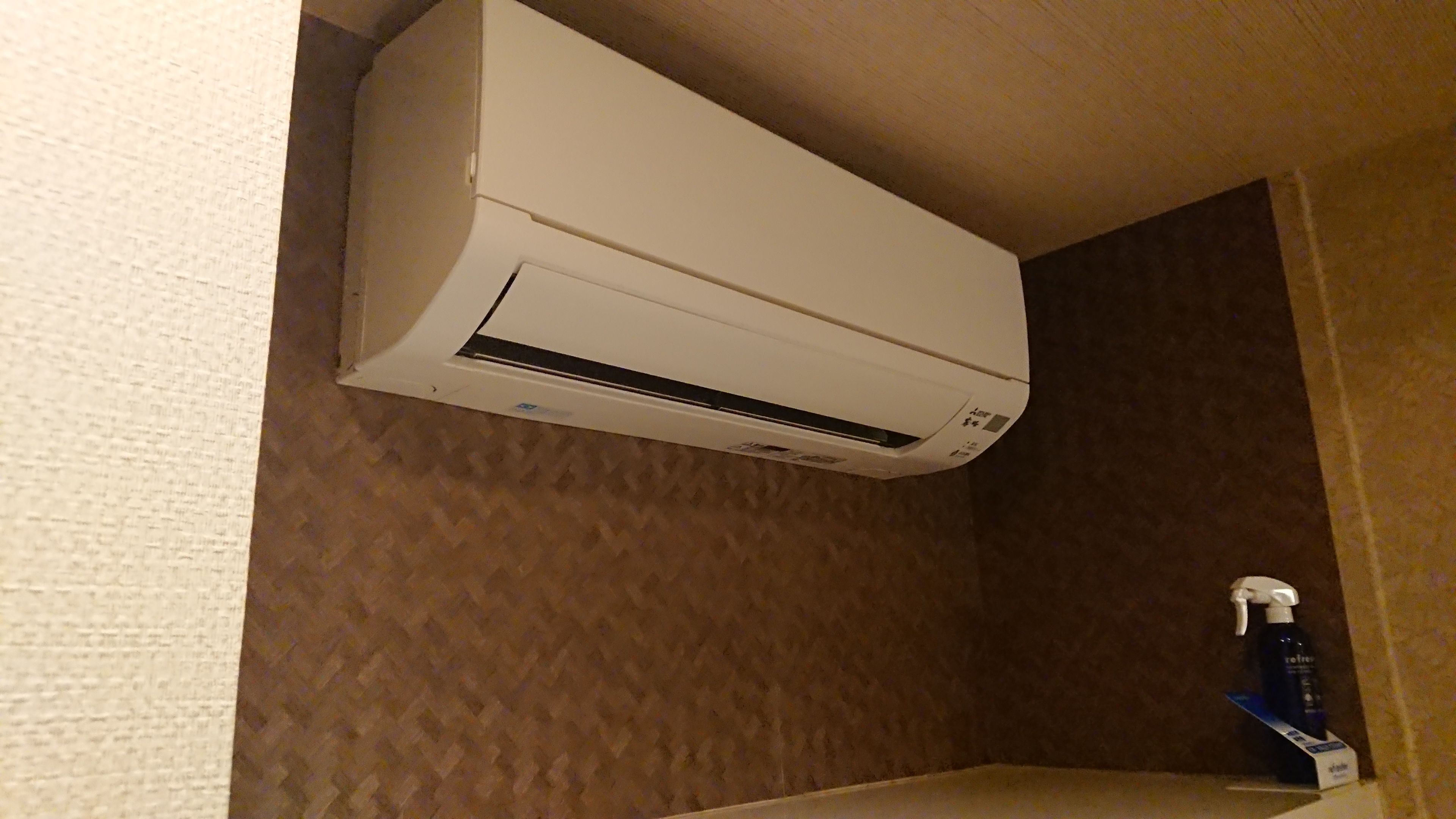 Um aparelho de ar condicionado branco fixado em uma parede com textura.