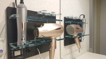 A hairdryer and a vacuum cleaner on a black shelf with glass shelves.