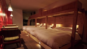 A room with a bunk bed, a chair, and a table with a lamp. - RYOKAN PLUM (Odawara)
