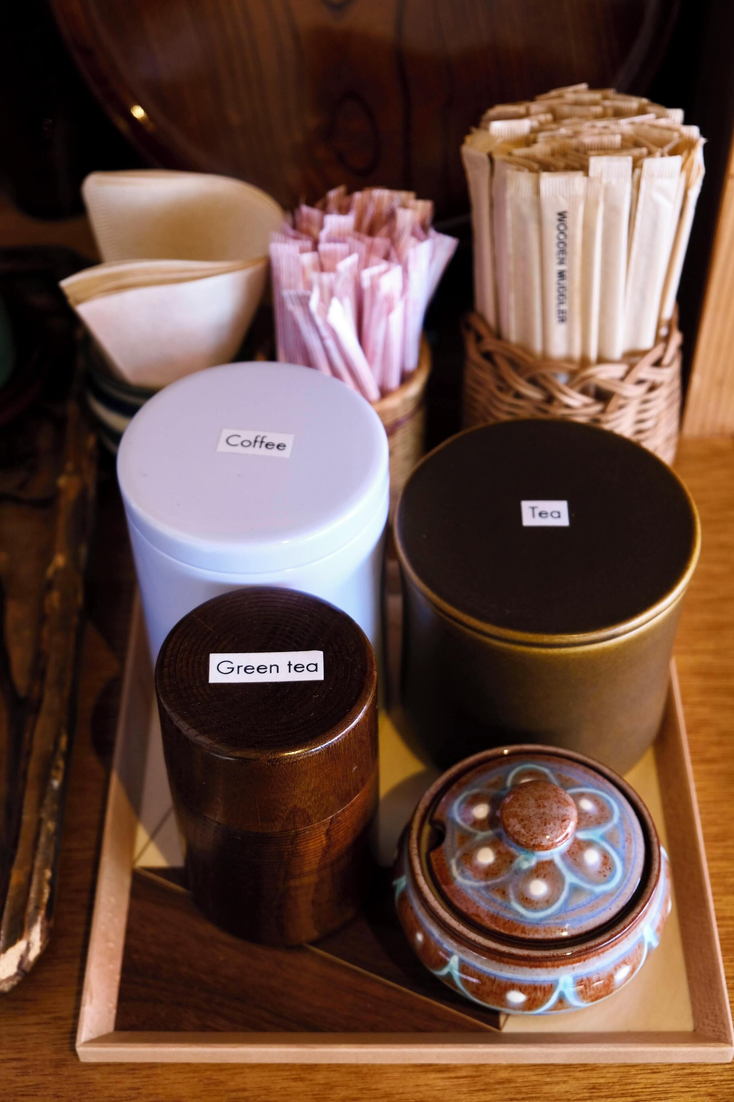 A tray with labeled containers of coffee, tea, and green tea.