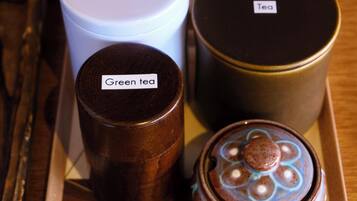 A tray with labeled containers of coffee, tea, and green tea.