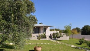 Une maison moderne avec un toit plat, un petit porche et une pelouse bien entretenue.