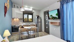 Une cuisine compacte avec un coin repas, un téléviseur et une fenêtre donnant sur un beau paysage.