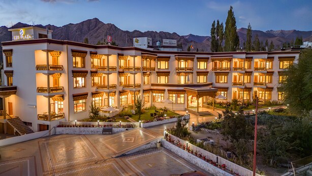 A multi-story hotel with balconies, a courtyard, and a mountainous backdrop. - Hotel Leh Plaza (Leh)