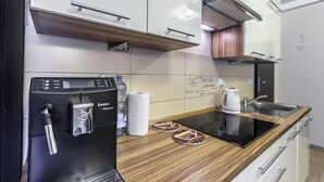 Moderni keittiö, jossa on sisäänrakennettu espressokone, kahvinkeitin ja mikroaaltouuni.