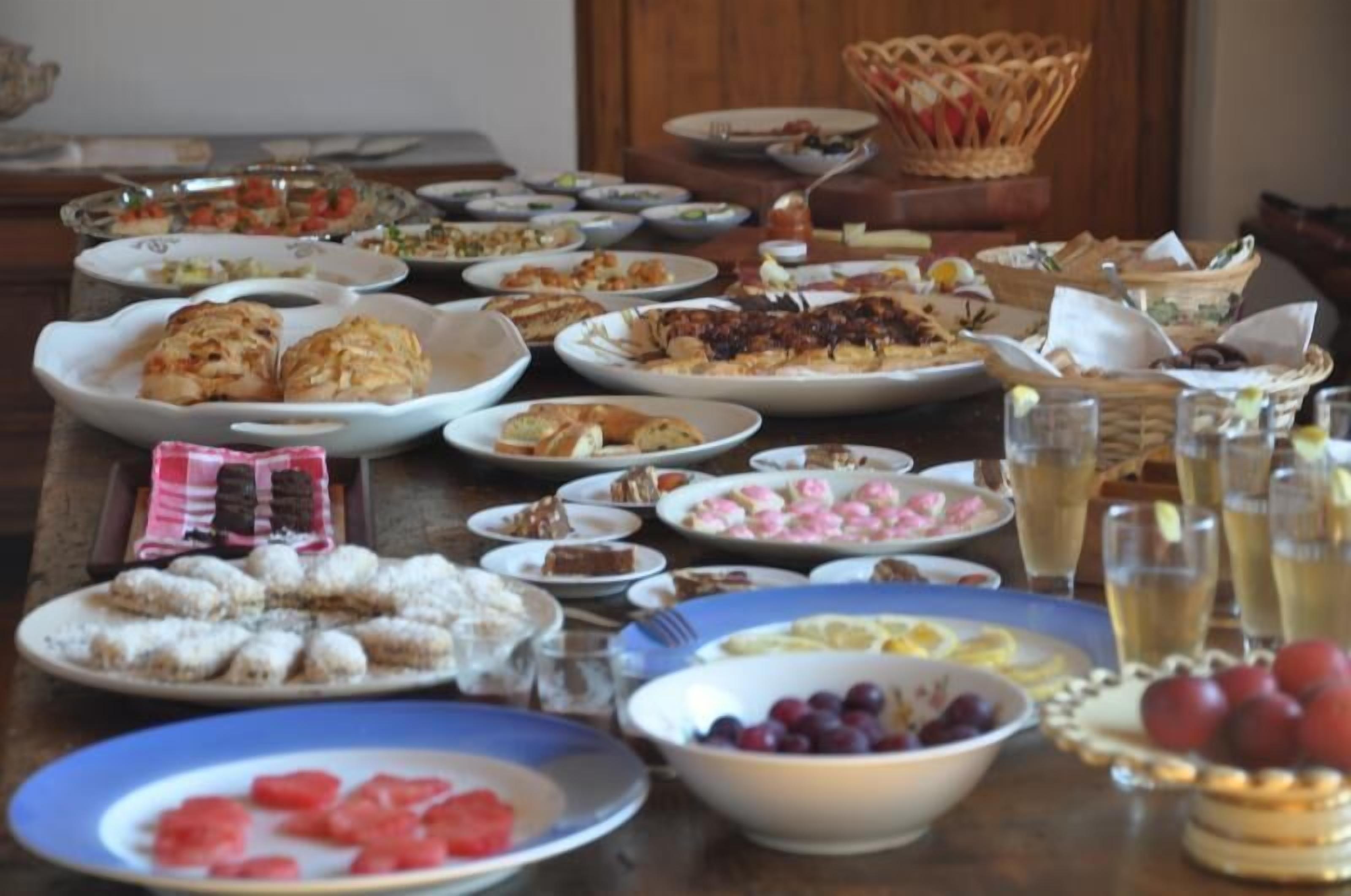 A table with various dishes and drinks, including plates of food, a basket, and glasses of beverages.