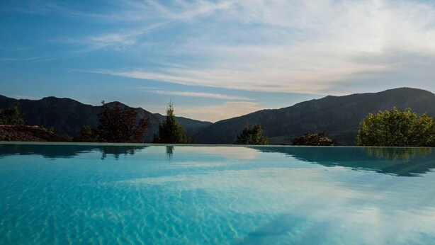 Ein klares Schwimmbecken mit Blick auf eine Berglandschaft.