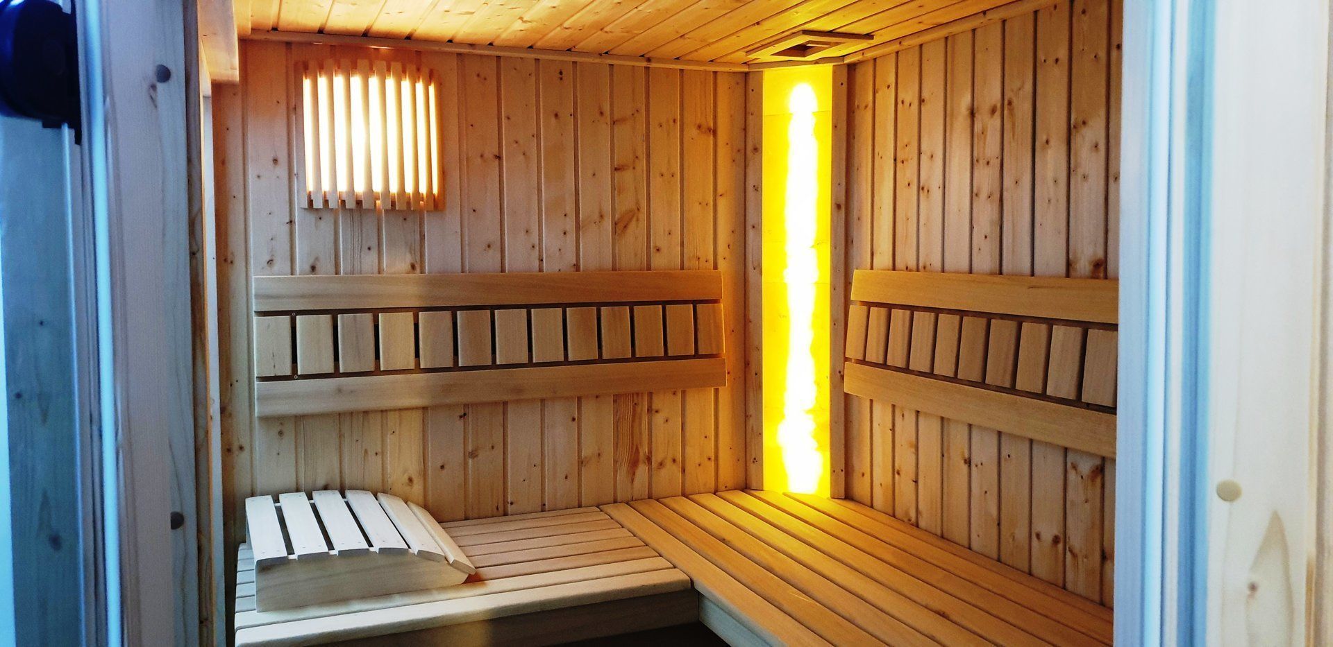 Una sauna con panche di legno e una luce centrale.