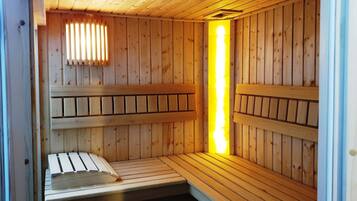 Una sauna con panche di legno e una luce centrale.