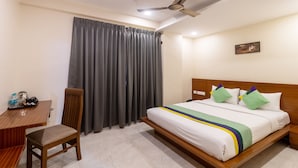 A hotel room with a bed, a desk with a chair, a coffee maker, and a telephone. - Treebo Anjani Fortune Suites (Bengaluru)