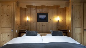 Ein Schlafzimmer mit Holzwand, einem Bett, zwei Nachttischen und einem gerahmten Bild an der Wand.