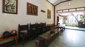 Una habitación con bancos de madera, una mesa con cubierta de vidrio y obras de arte enmarcadas en las paredes.