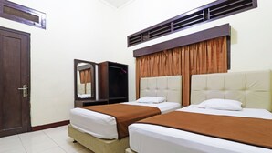 Una habitación de hotel con dos camas, un armario, un espejo y una puerta.