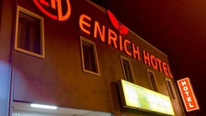 The exterior of the Enrich Hotel with illuminated signage and a neon sign indicating it is a hotel. - Enrich Hotel (Sungai Buloh)