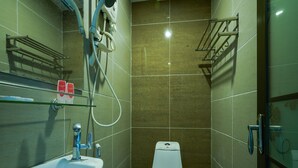 A small, modern bathroom with a white sink, a toilet, and a shower area. - Enrich Hotel (Sungai Buloh)