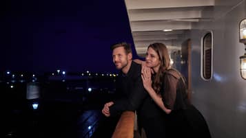 A couple on a cruise ship deck at night.