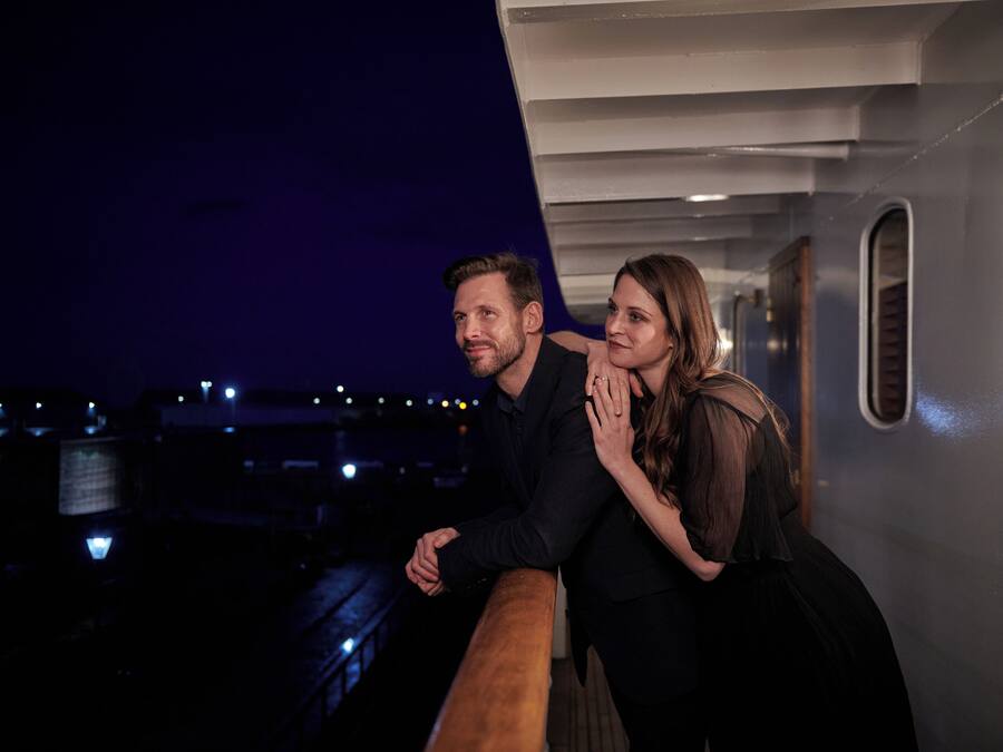 A couple on a cruise ship deck at night.