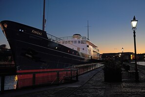 A large ship docked at a port with a clear sky.