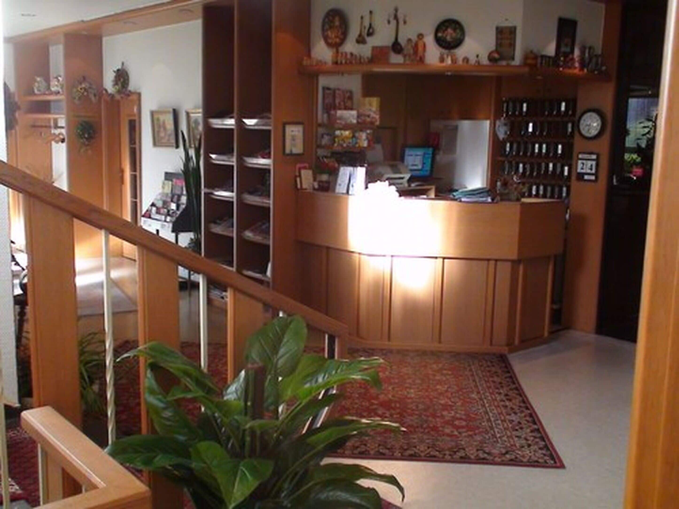 Un bureau à domicile équipé d’un bureau, d’un ordinateur et d’étagères où sont rangés des livres et des objets décoratifs.