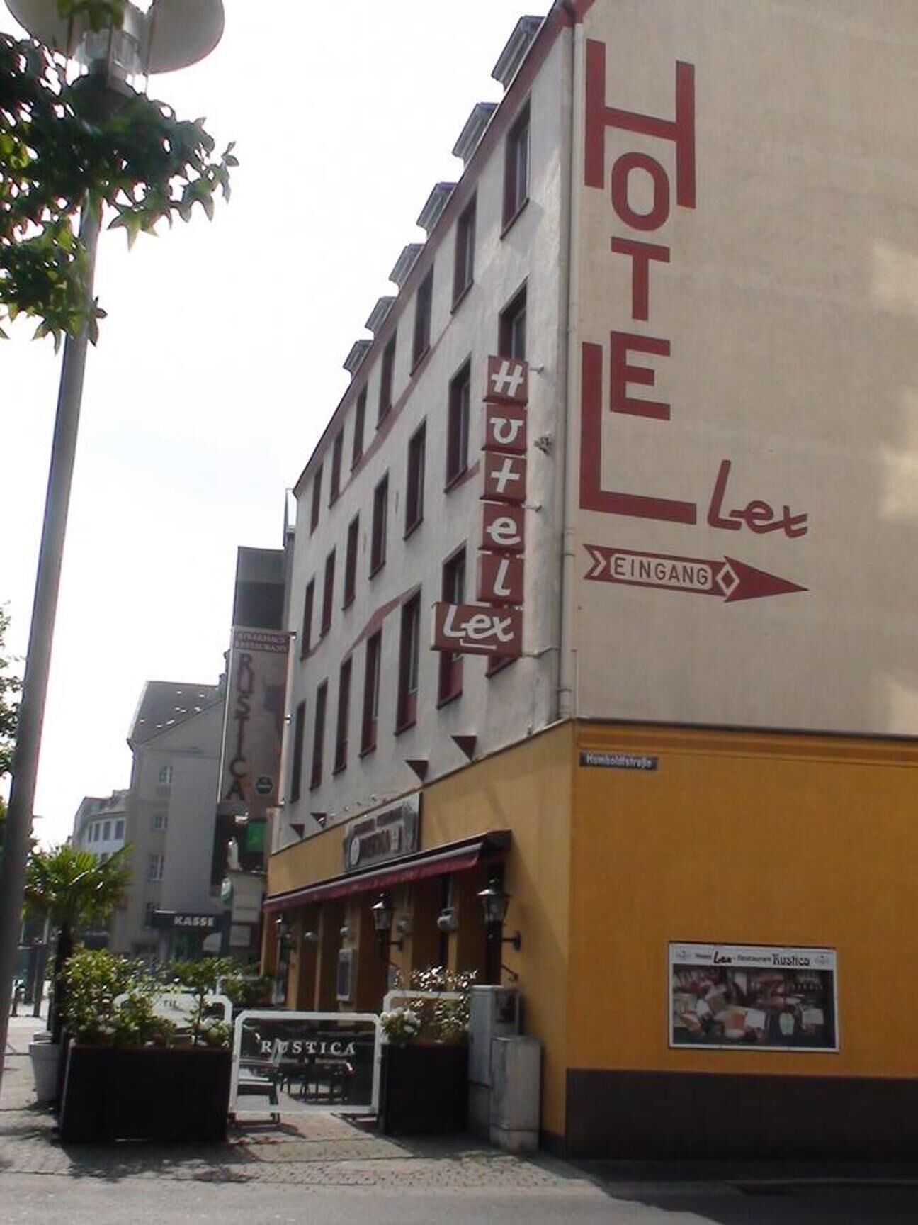 Un edificio de hotel con un cartel que indica 'Hotel Let' y 'Eingang' (Entrada).