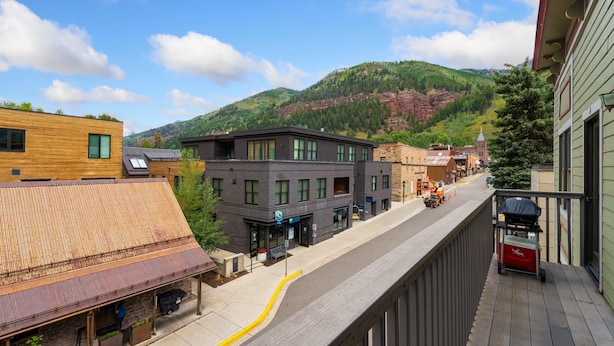 A street view with buildings, a clear sky, and a mountain in the background. - Centrally Located Condo | Walk to Gondola, Lift 8, Dining & River Trail (Telluride)