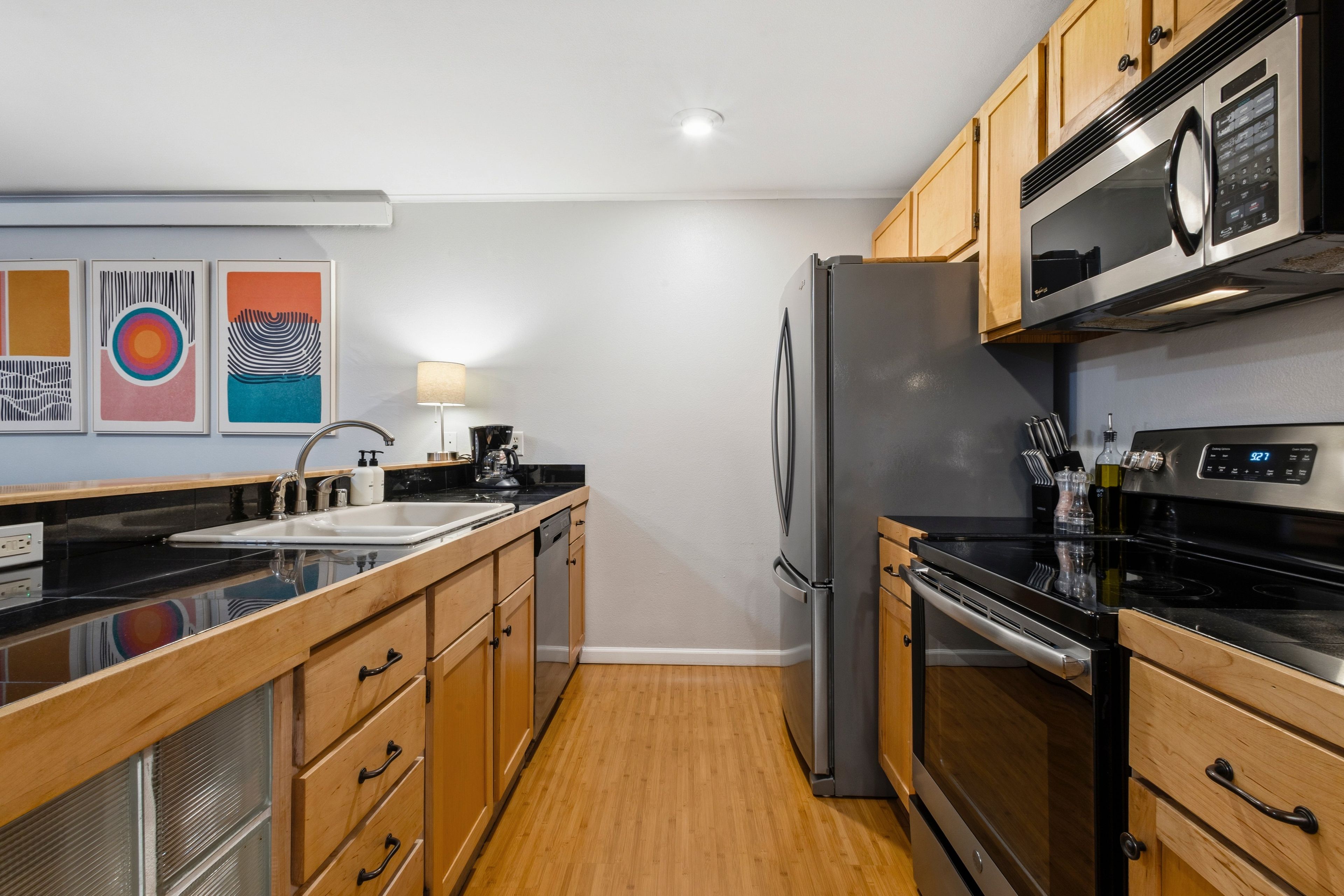 Una cocina moderna con armarios de madera, un refrigerador de acero inoxidable, un microondas y una estufa.
